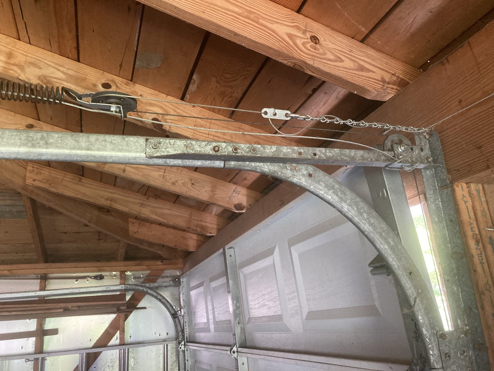 Technician performing garage door track repair to fix alignment issues in a residential garage in Delaware