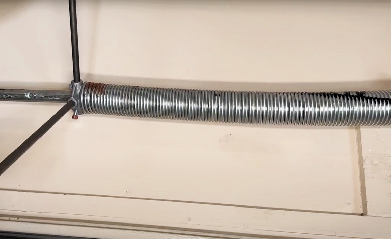 Close-up of a broken garage door spring being repaired by a technician at Delaware Garage Door Repair.